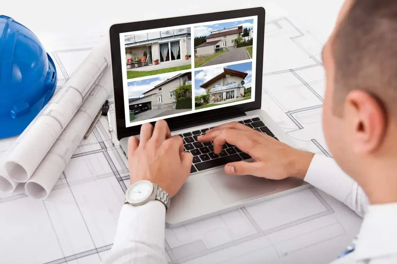 Arquitecto revisando su portafolio de proyectos sobre planos arquitectónicos